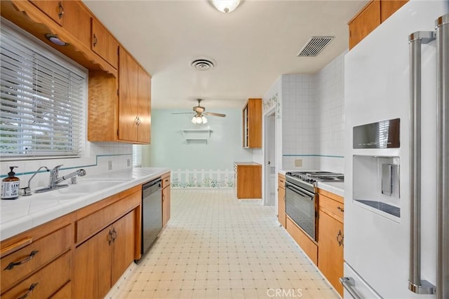 kitchen featuring visible vents, range with gas cooktop, a sink, white fridge with ice dispenser, and stainless steel dishwasher