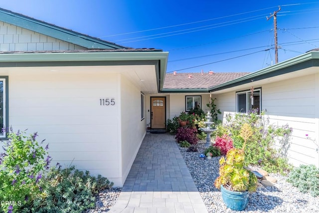 entrance to property with roof with shingles