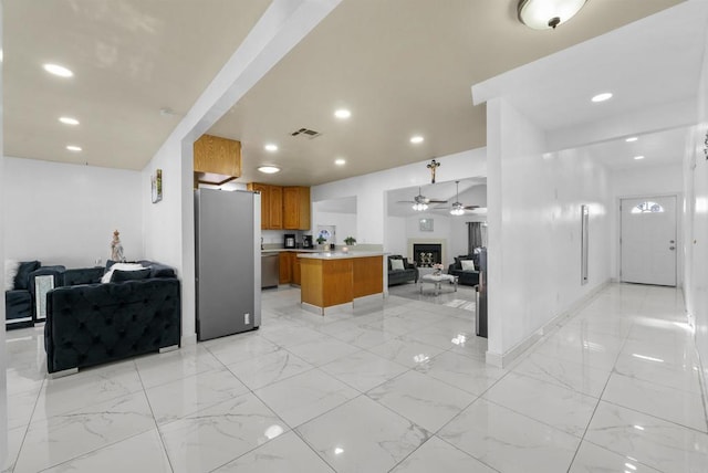 kitchen featuring visible vents, open floor plan, light countertops, brown cabinets, and stainless steel appliances