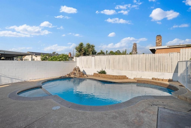 view of swimming pool with a fenced backyard and a pool with connected hot tub