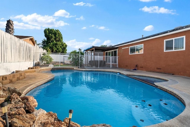 view of pool with a patio area, a fenced in pool, an in ground hot tub, and a fenced backyard