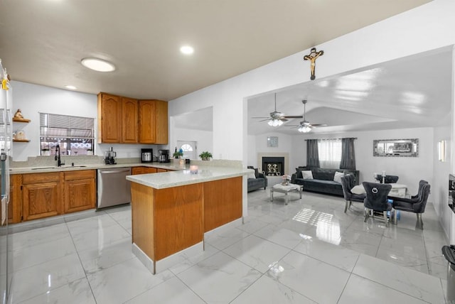 kitchen with dishwasher, light countertops, a peninsula, marble finish floor, and a sink