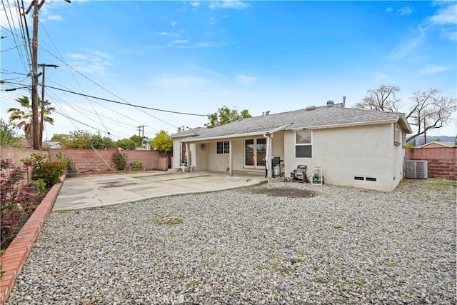 rear view of property with a fenced backyard, a shingled roof, stucco siding, crawl space, and a patio area