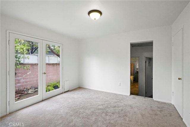 empty room featuring french doors, baseboards, and carpet floors