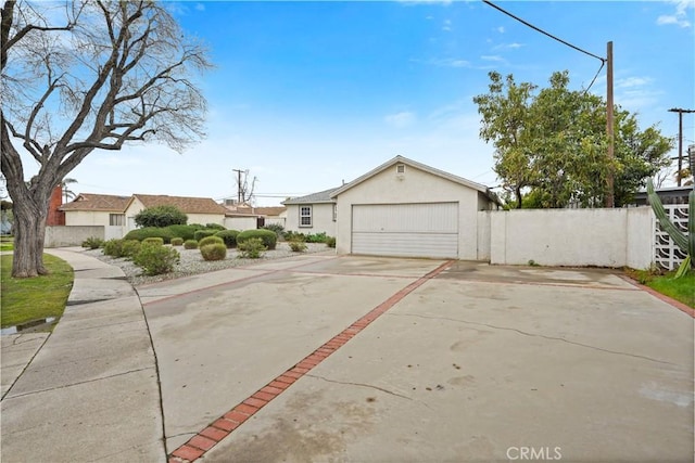 exterior space with stucco siding, driveway, a garage, and fence