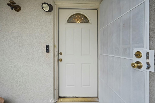 doorway to property featuring stucco siding