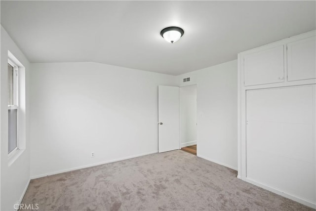 unfurnished bedroom with carpet flooring, baseboards, visible vents, and a closet