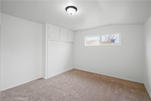 interior space featuring lofted ceiling and baseboards