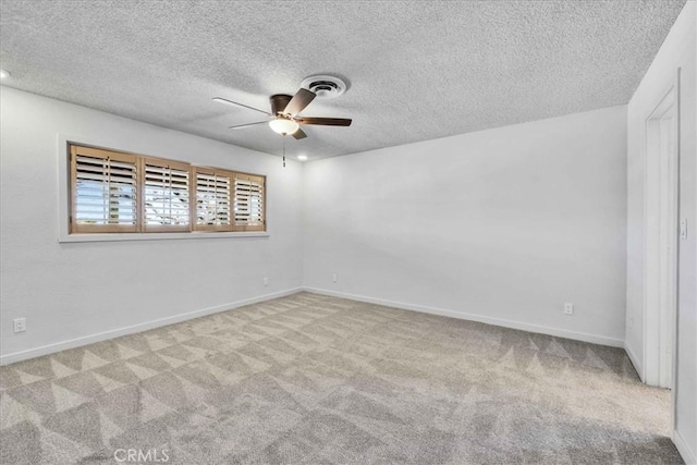 unfurnished room with a ceiling fan, visible vents, carpet, baseboards, and a textured ceiling