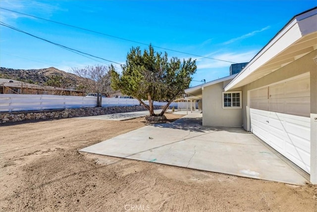 view of patio / terrace with a mountain view, a garage, and fence