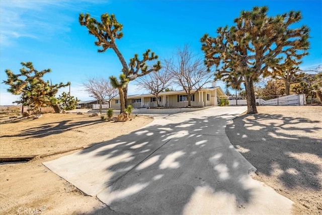 view of front of property featuring concrete driveway and fence