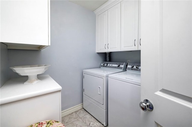 clothes washing area featuring washing machine and clothes dryer, cabinet space, marble finish floor, and baseboards