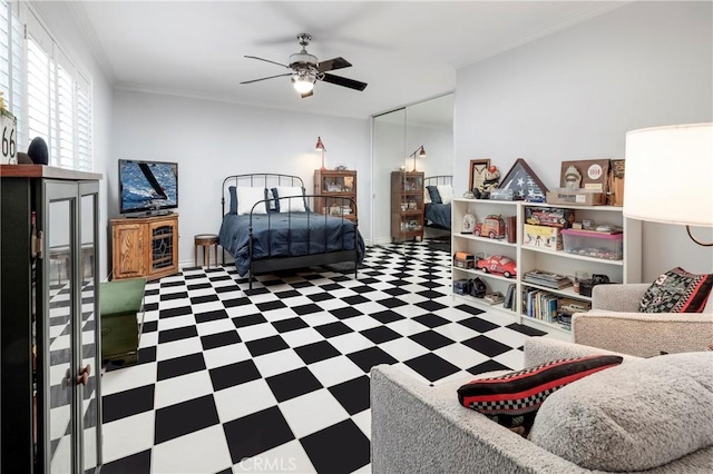 bedroom with tile patterned floors, a ceiling fan, crown molding, and a closet