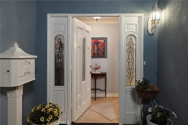 hall featuring tile patterned flooring and baseboards