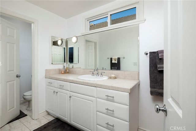 bathroom featuring vanity, toilet, and marble finish floor