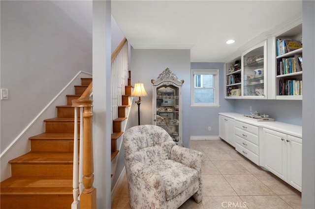 sitting room with light tile patterned floors, baseboards, recessed lighting, ornamental molding, and stairs