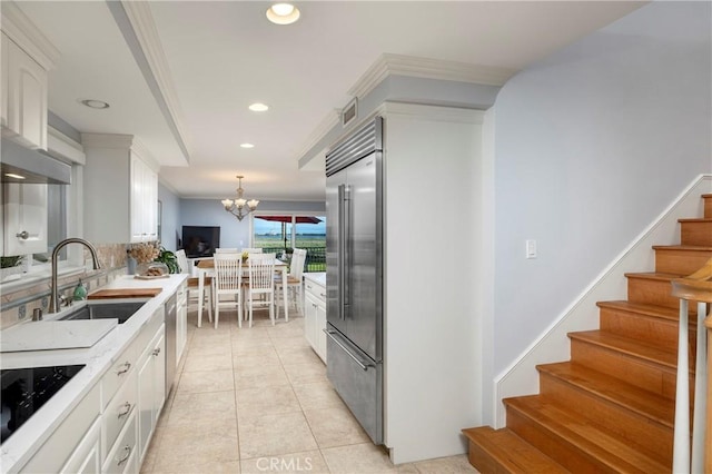 kitchen with appliances with stainless steel finishes, white cabinetry, light countertops, and a sink