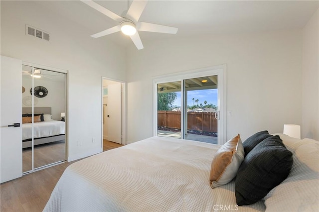 bedroom featuring visible vents, a ceiling fan, access to outside, wood finished floors, and lofted ceiling