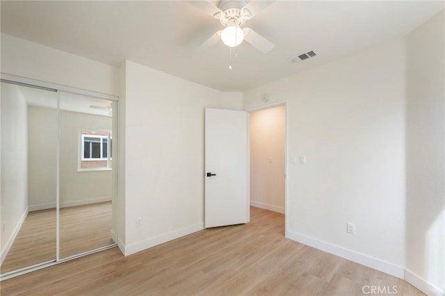 unfurnished bedroom featuring baseboards, visible vents, a closet, and light wood-type flooring