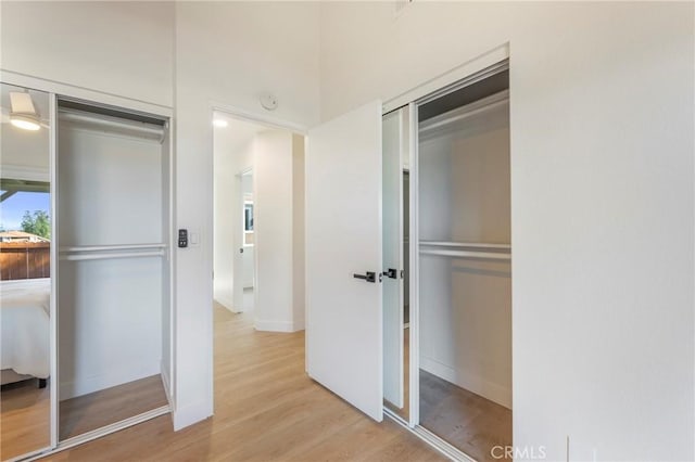 interior space featuring baseboards and light wood finished floors