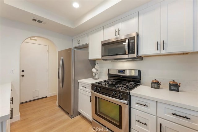 kitchen with visible vents, light wood finished floors, appliances with stainless steel finishes, and white cabinetry