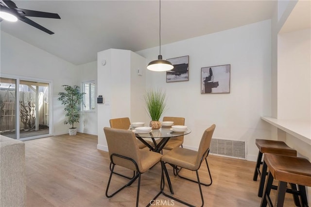 dining room with visible vents, a ceiling fan, light wood-type flooring, and lofted ceiling