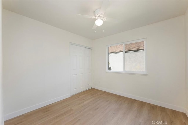 unfurnished room with light wood-style floors, baseboards, and ceiling fan