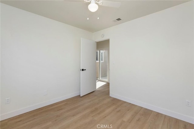 unfurnished room with light wood-type flooring, baseboards, visible vents, and ceiling fan