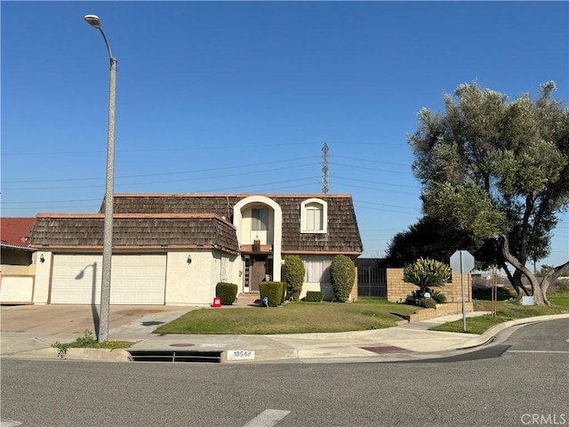 view of property with a front lawn, mansard roof, concrete driveway, and a garage