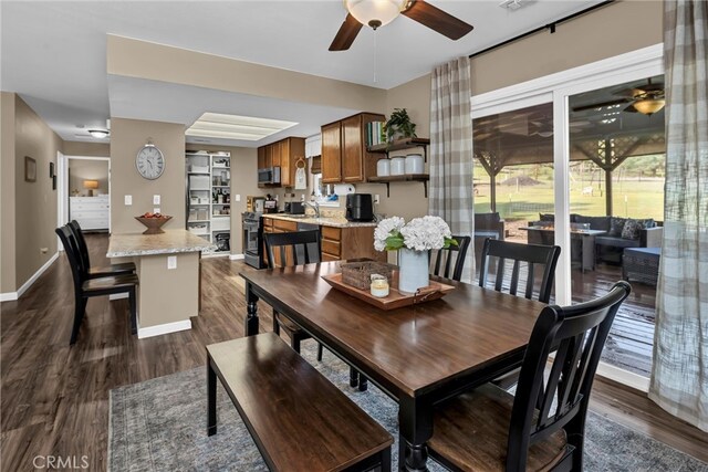 dining room with dark wood finished floors, baseboards, and ceiling fan