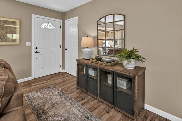 foyer entrance with baseboards and wood finished floors