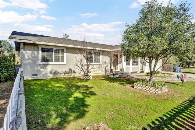 ranch-style house featuring a shingled roof, concrete driveway, a front yard, crawl space, and an attached garage