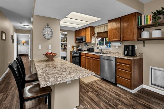 kitchen with a sink, dark wood finished floors, a kitchen bar, stainless steel appliances, and open shelves