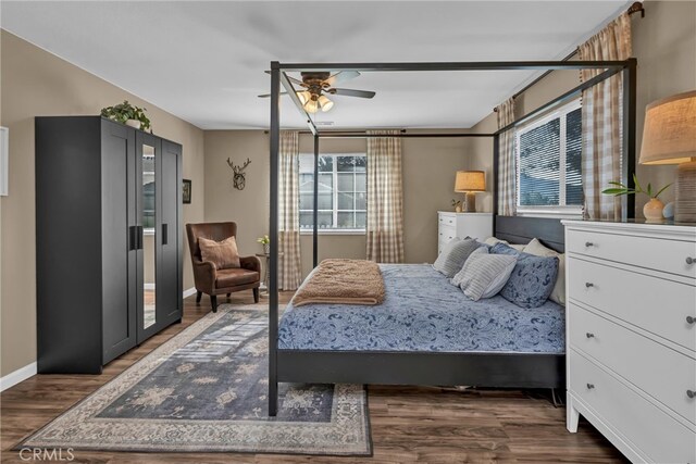 bedroom featuring baseboards, wood finished floors, and a ceiling fan