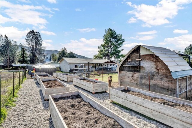 view of yard featuring an outbuilding, a garden, and fence