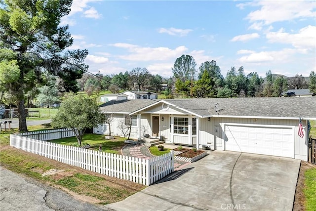 single story home with an attached garage, a shingled roof, a fenced front yard, a front yard, and driveway