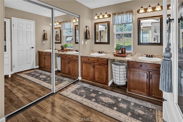 bathroom with double vanity, wood finished floors, and a sink