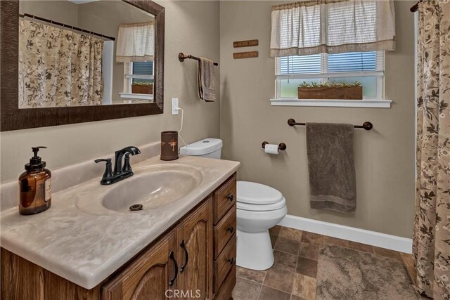 bathroom featuring a shower with shower curtain, baseboards, toilet, and vanity