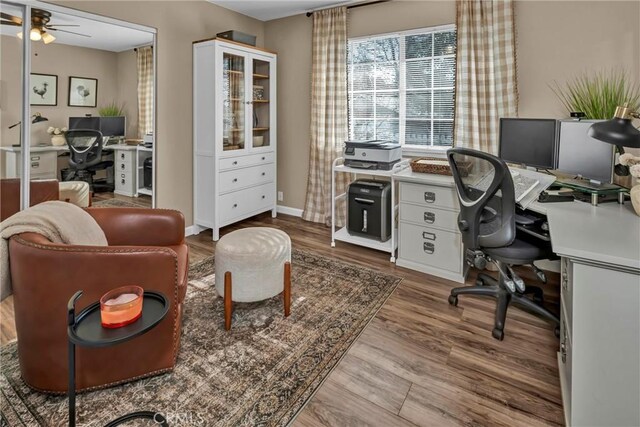 home office featuring baseboards, wood finished floors, and a ceiling fan