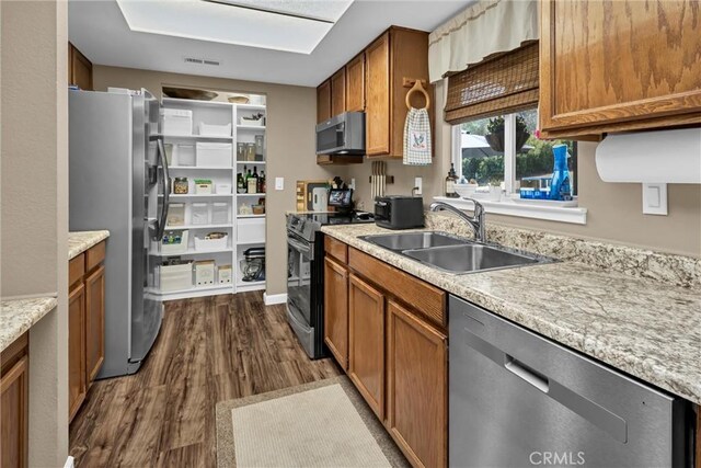 kitchen with brown cabinets, stainless steel appliances, and a sink