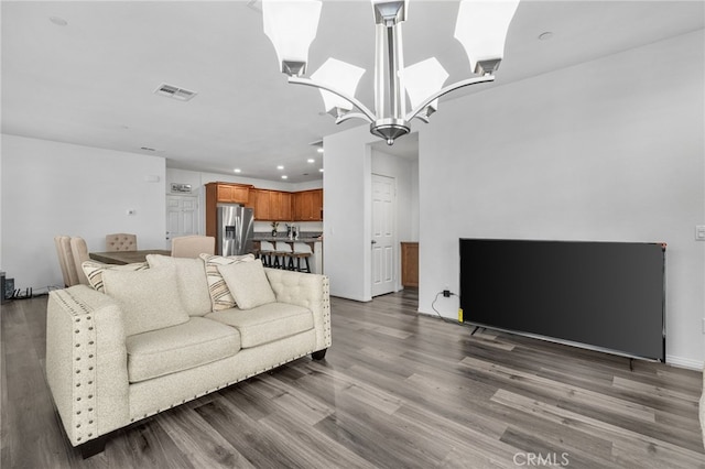 living area with recessed lighting, visible vents, a notable chandelier, and wood finished floors