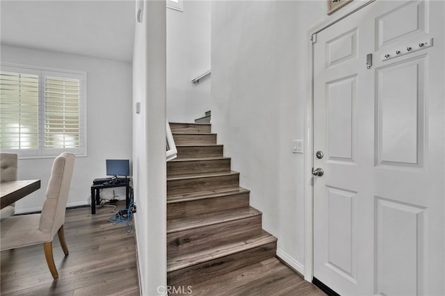 stairs with wood finished floors and baseboards