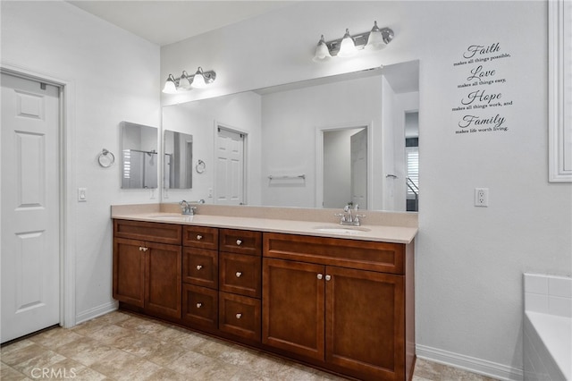 full bath featuring double vanity, a bathtub, baseboards, and a sink