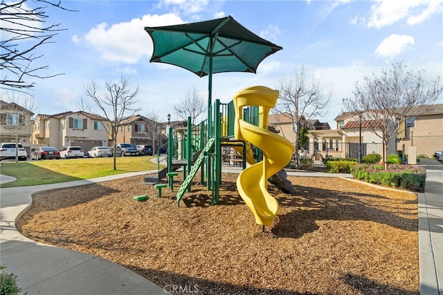 community play area with a residential view, a lawn, and fence