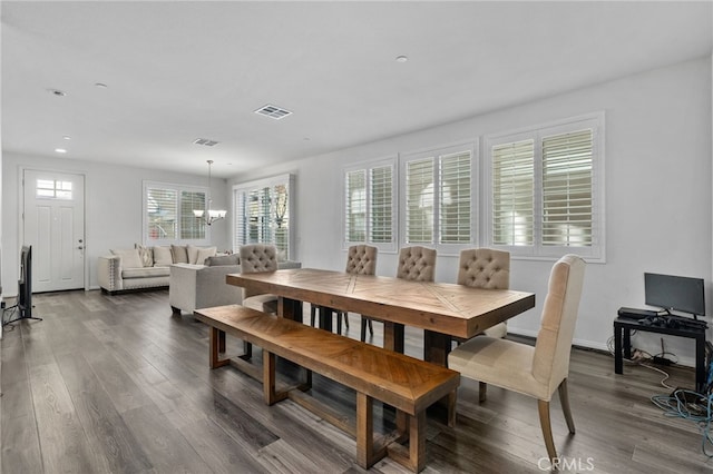 dining room with dark wood finished floors, plenty of natural light, visible vents, and a chandelier