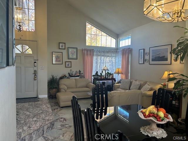 30103 Desert Rose Dr, Castaic, CA 91384 - living room featuring high vaulted ceiling, marble finish flooring, and a chandelier