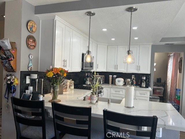 30103 Desert Rose Dr, Castaic, CA 91384 - kitchen featuring a peninsula, backsplash, white cabinets, recessed lighting, and a textured ceiling