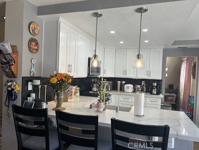 30103 Desert Rose Dr, Castaic, CA 91384 - kitchen featuring a peninsula, tasteful backsplash, white cabinets, recessed lighting, and a textured ceiling
