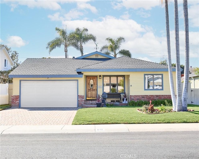 ranch-style house with a garage, decorative driveway, brick siding, and a front lawn