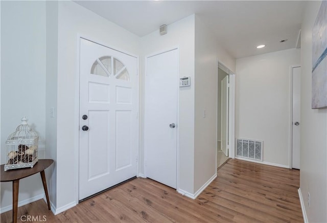 foyer featuring visible vents, recessed lighting, light wood-type flooring, and baseboards